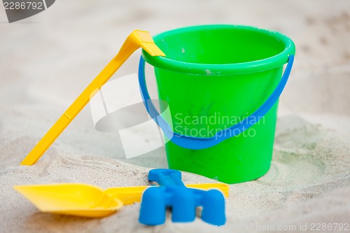 Image of plastik colorful toys in sand on beach