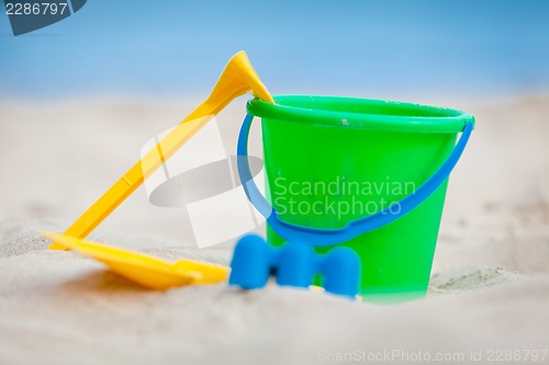 Image of plastik colorful toys in sand on beach