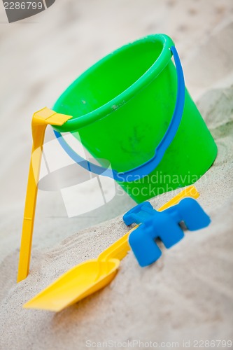 Image of plastik colorful toys in sand on beach