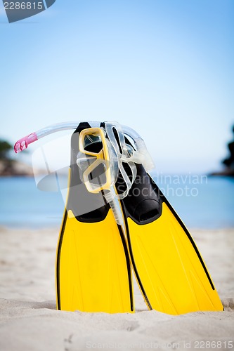 Image of yellow fins and snorkelling mask on beach in summer