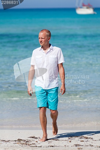 Image of young man walking on the beach in holiday