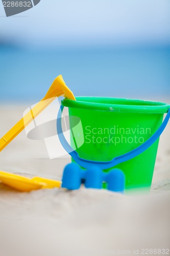 Image of plastik colorful toys in sand on beach