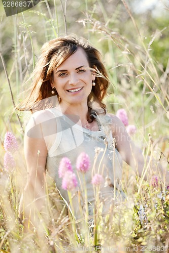 Image of adult brunette woman smiling in summertime outdoor