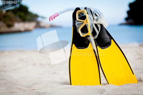 Image of yellow fins and snorkelling mask on beach in summer