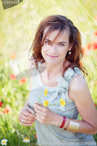 Image of adult brunette woman smiling in summertime outdoor