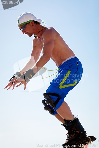 Image of young man with inline skates in summer outdoor 