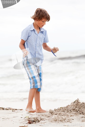 Image of little boy playing in sand on the beach