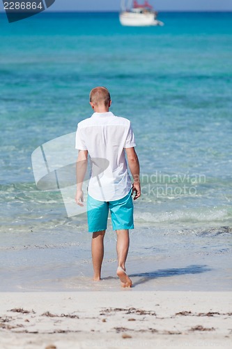 Image of young man walking on the beach in holiday