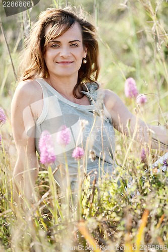 Image of adult brunette woman smiling in summertime outdoor