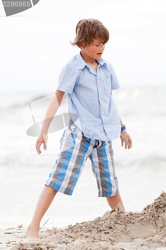 Image of little boy playing in sand on the beach