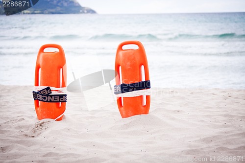 Image of orange red life buoy in sand on beach at the sea object