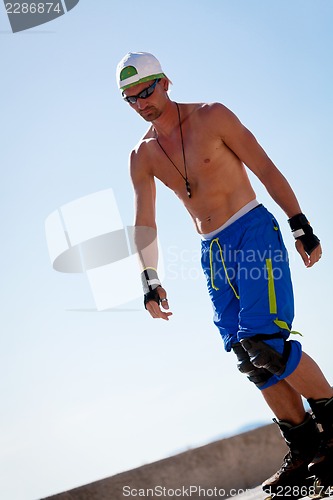 Image of young man with inline skates in summer outdoor 