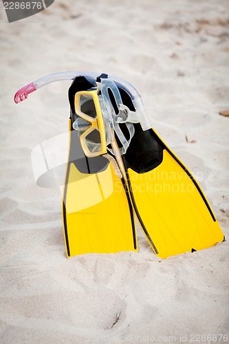 Image of yellow fins and snorkelling mask on beach in summer