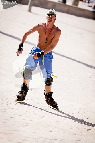 Image of young man with inline skates in summer outdoor 