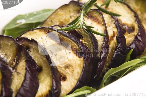 Image of Grilled eggplant slices on a plate with fresh rosemary
