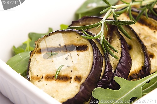 Image of Grilled eggplant slices on a plate with fresh rosemary