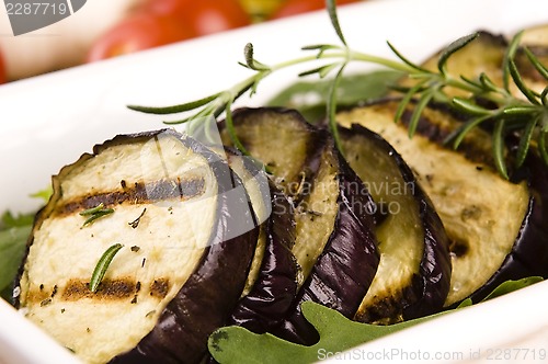 Image of Grilled eggplant slices on a plate with fresh rosemary