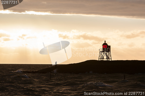 Image of Silhouette of a red beacon at the dutch coast