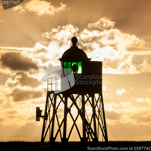 Image of Silhouette of a green beacon at the dutch coast