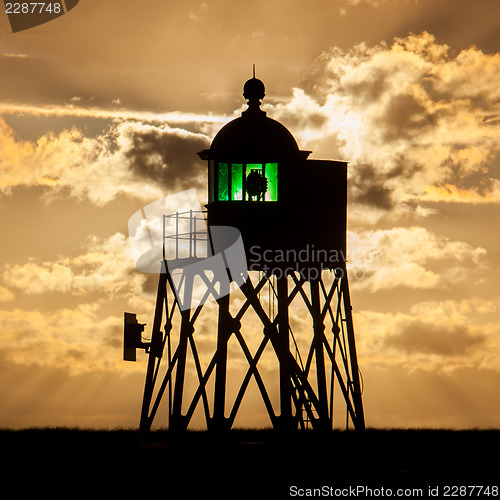 Image of Silhouette of a green beacon at the dutch coast