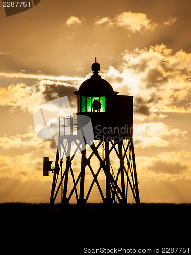 Image of Silhouette of a green beacon at the dutch coast