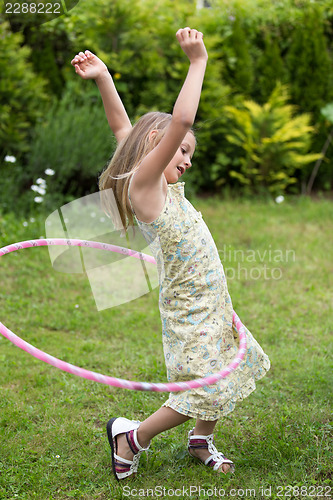 Image of Little girl playing with hula hoop