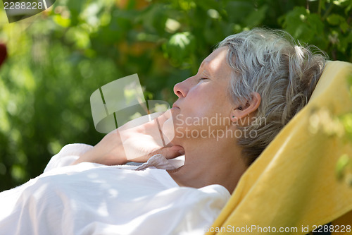 Image of Aged woman sleeping on lounger