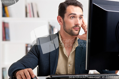 Image of Suprised Man Looking At A Computer Monitor