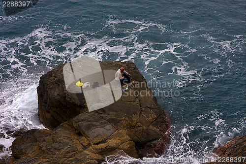 Image of fisherman abstract rock water 