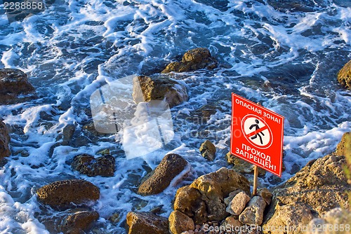 Image of Danger! No walking sign on the rocky sea coast