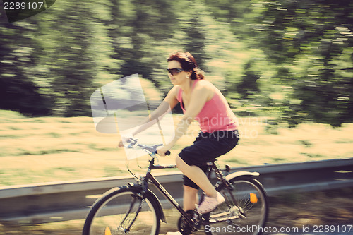 Image of pretty woman riding a bicycle