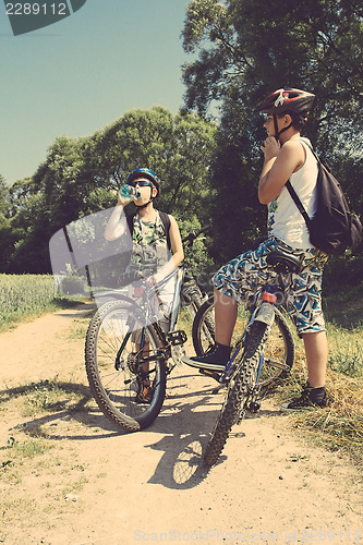 Image of Two teenagers relaxing on a bike trip