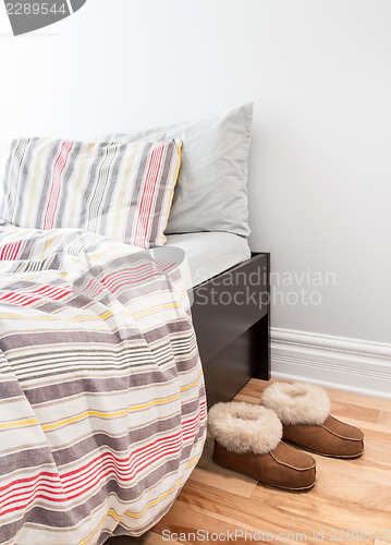 Image of Warm cozy slippers near bed