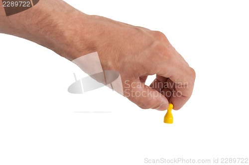 Image of Hand holding a yellow pawn