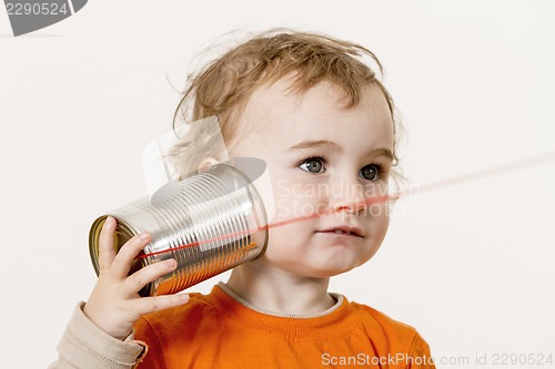 Image of young child listening to tin can phone