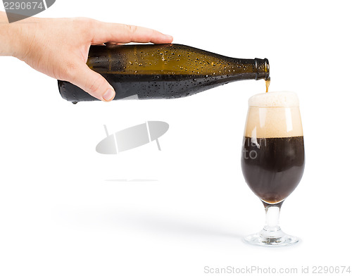 Image of Hand holding bottle of beer and beer mug