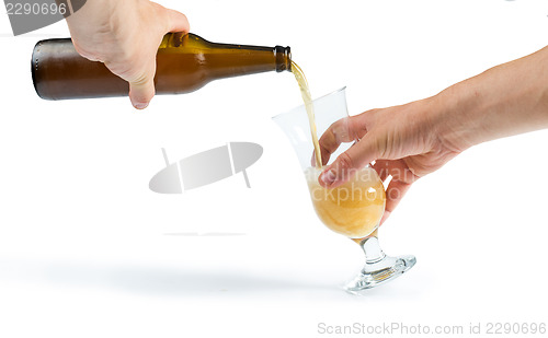 Image of Hand holding bottle of beer and beer mug