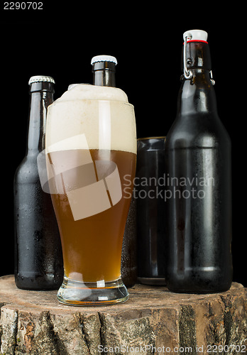 Image of Bottles of beer and beer mug on stump