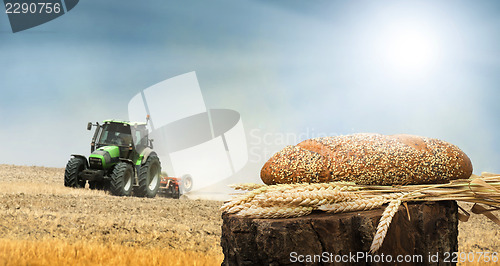 Image of Bread and wheat cereal crops.Traktor on the background