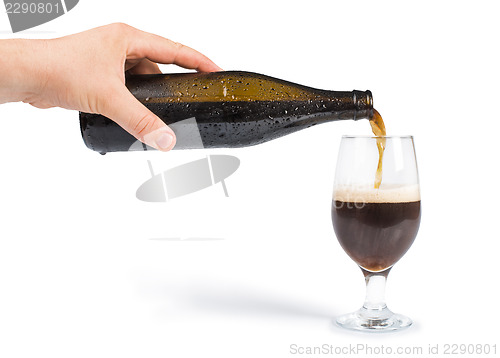 Image of Hand holding bottle of beer and beer mug