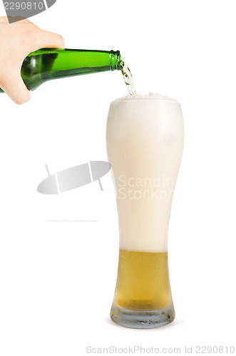 Image of Hand holding bottle of beer and beer mug