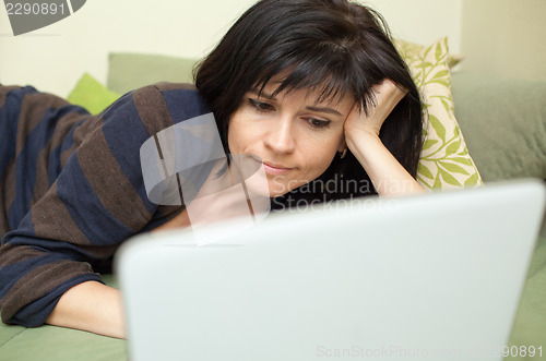 Image of Woman with laptop on sofa