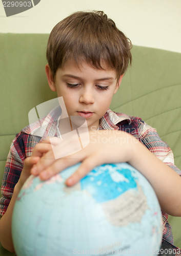 Image of Little boy looking at globe