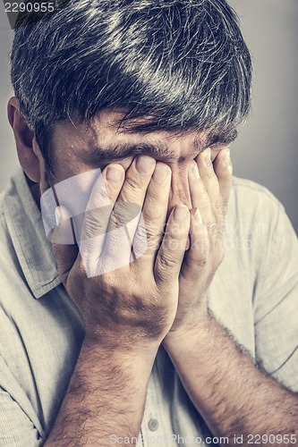 Image of man covered his face