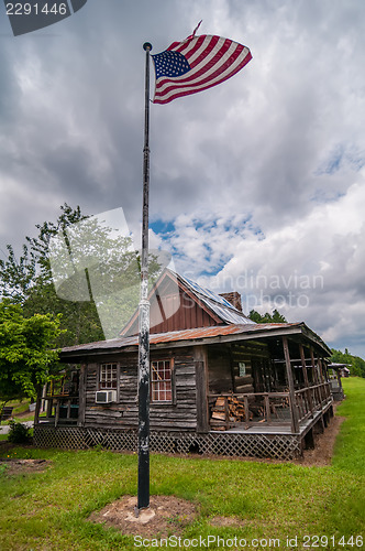 Image of old log cabin and american flag