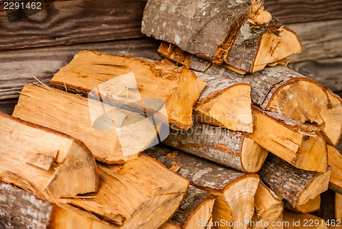 Image of chopped fire wood next to log cabin