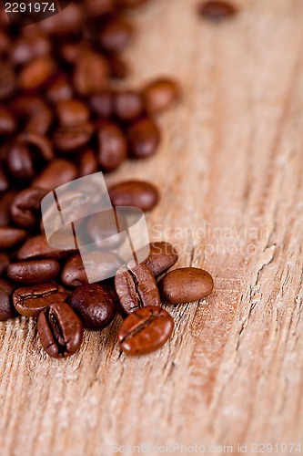 Image of fresh coffee beans on rustic wooden board 