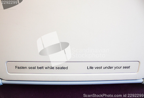 Image of Airplane seat back with caution inform on flight