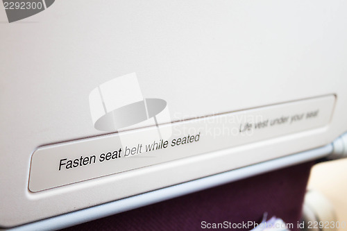 Image of Airplane seat back with caution inform on the flight