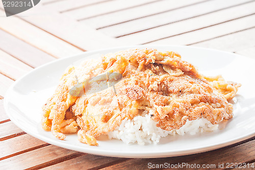 Image of Fast cooking of fried omelet topped on rice 